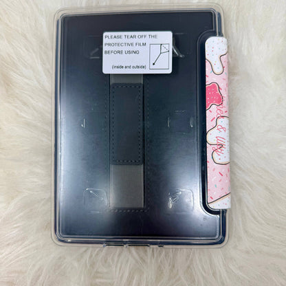 Black E-Reader case with a pink and white patterned strip on a light brown surface