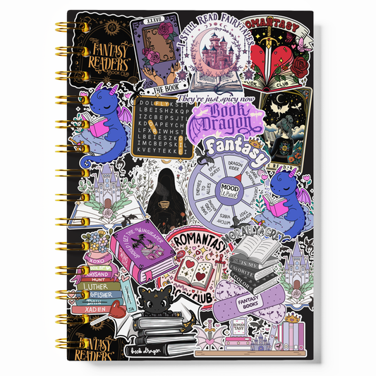 A spiral-bound notebook covered in a dense collage of gothic fantasy-themed stickers, including book illustrations, a purple dragon, tarot card designs, and text such as 'Fantasy Readers' and 'Book Dragon Fantasy Club,' shown on a plain white background.