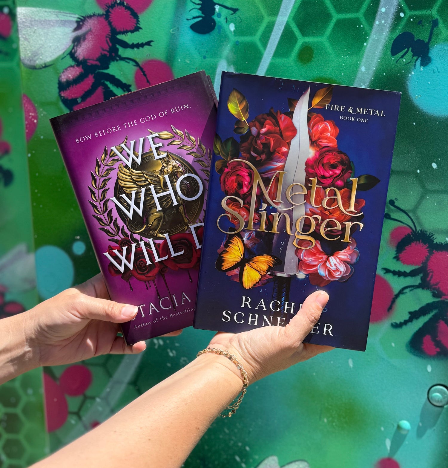 Two books held in front of a colorful background with bee illustrations